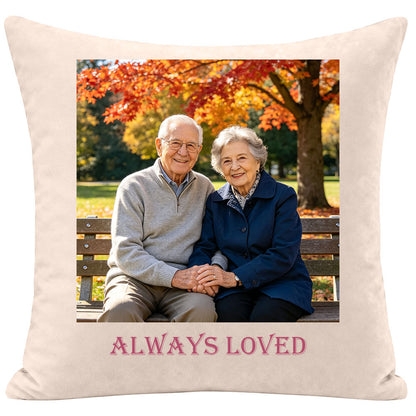 Custom sympathy pillow with a vintage photo of an elderly couple holding hands on an autumn park bench, engraved with "Always Loved", keepsake gift for remembering grandparents or spouses, soft cream fabric memorial throw pillow.