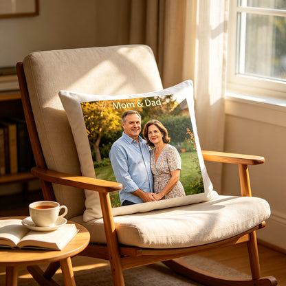 Custom Mom & Dad keepsake pillow resting on a classic wooden rocking chair in a sunlit home library, with a book and coffee on the side table. A cozy, peaceful touch perfect for quiet evenings and family reminiscing.